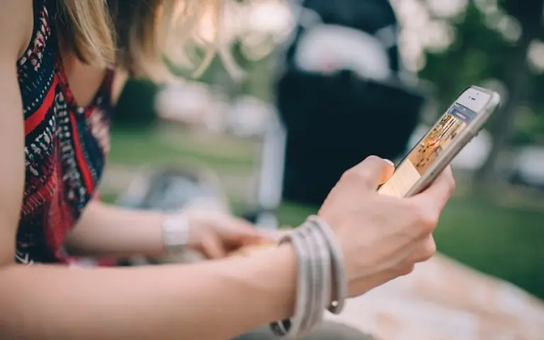 woman with bracelets and striped dress using a phone
