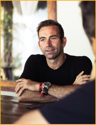 Man with a watch in black t-shirt talking and smiling