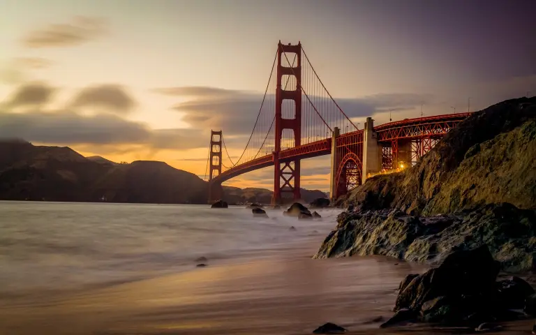 Bay Bridge in sunset with cliffs and beach